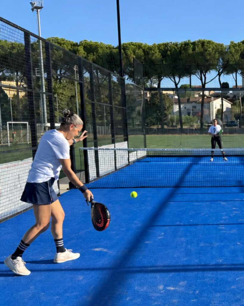 Una giocatrice prepara il servizio sul campo blu da padel durante i Campionati ASI 2026